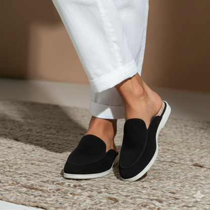 Mule noire élégante portée avec pantalon blanc – confort & style