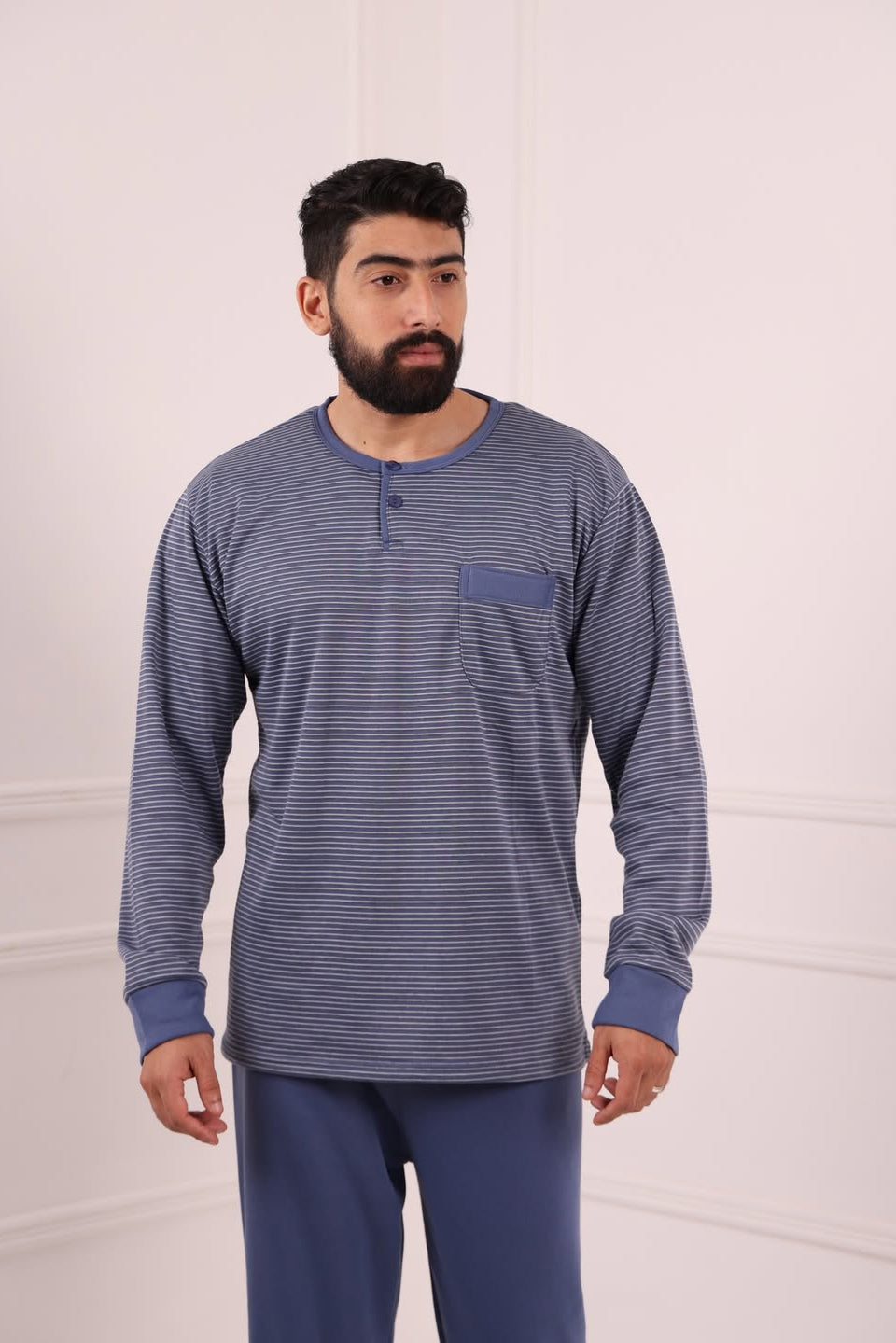 Homme portant un pyjama bleu rayé confortable pour l’hiver، tenue d’intérieur élégante pour la maison et le sommeil، style moderne au Maroc